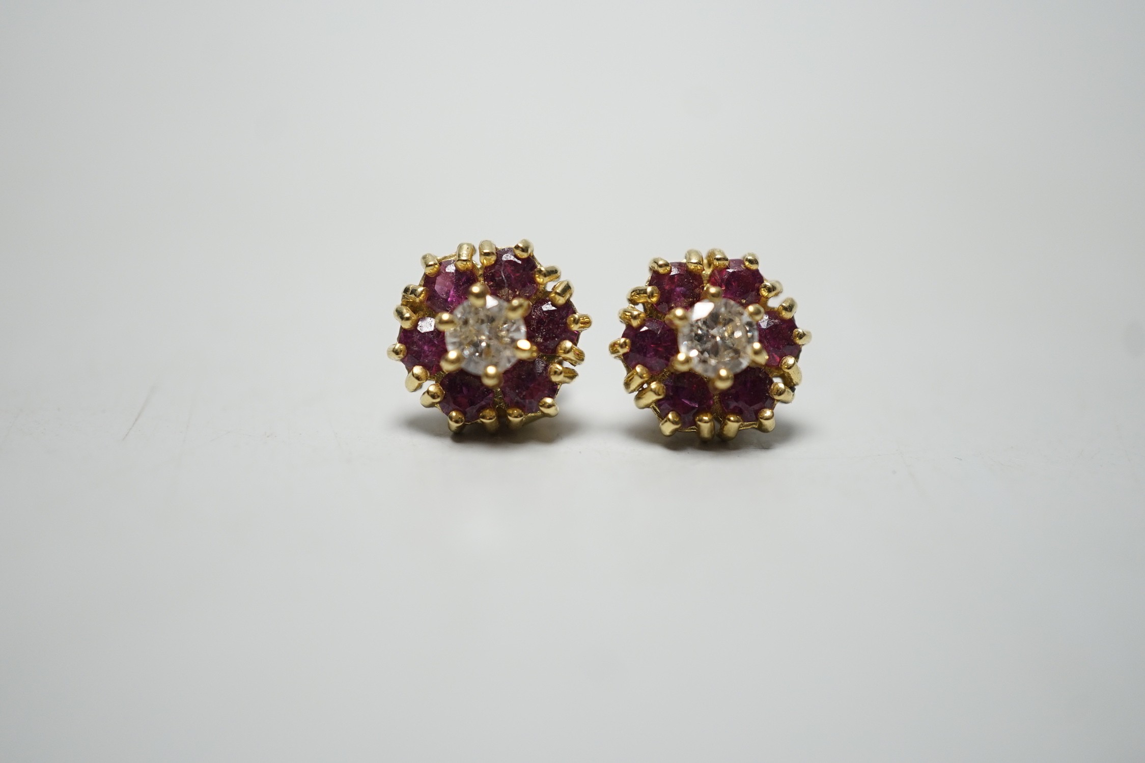 A pair of 18ct gold, diamond and garnet? circular cluster ear studs, 9mm, gross weight 4 grams.